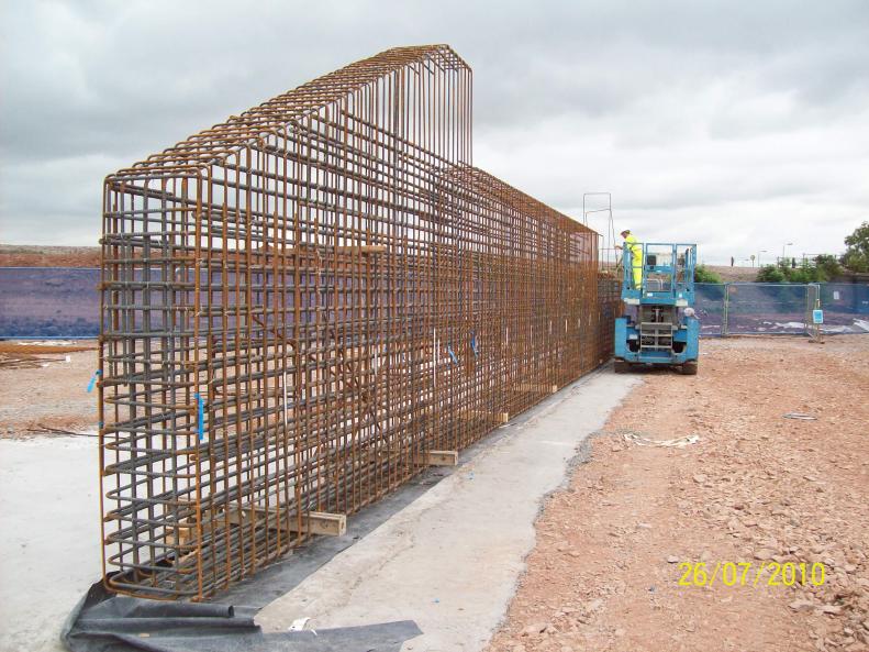 Steel cage being fixed - Note the timbers being used to stop the cage falling over.