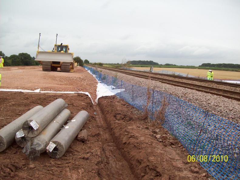 Stone being placed as close as possible to the existing emabankment.