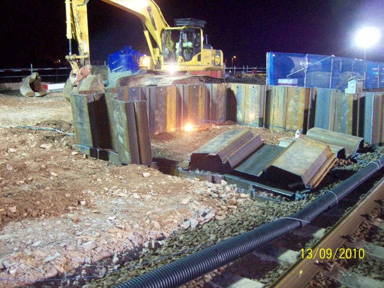 Top section of sheet piles being cut down.