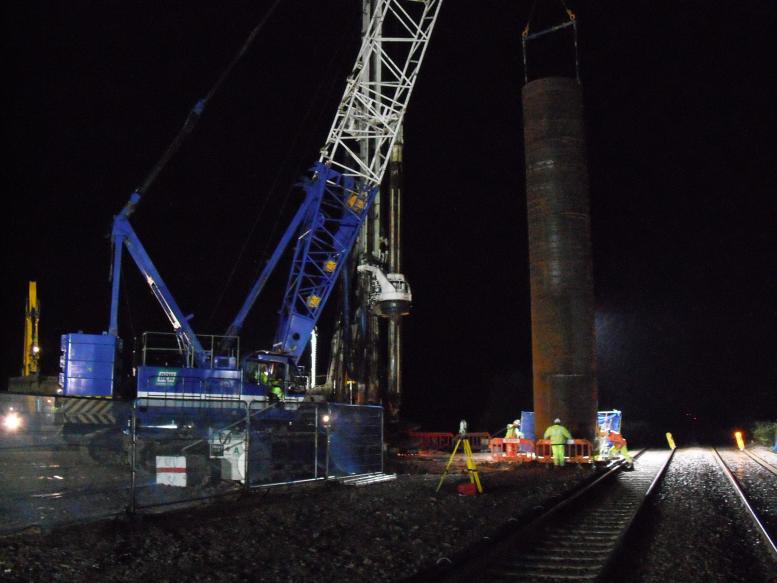 Crane lifting the steel casing into the pre-bore.