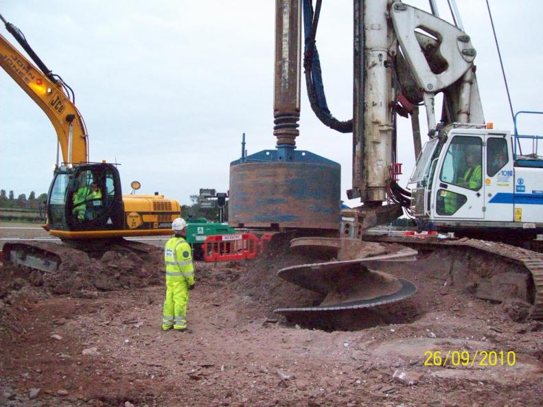 Pile rig drilling and cleaning out the bottom of the piles.