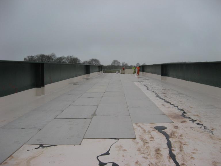 Waterseal laying the deck board to protect the waterproofing