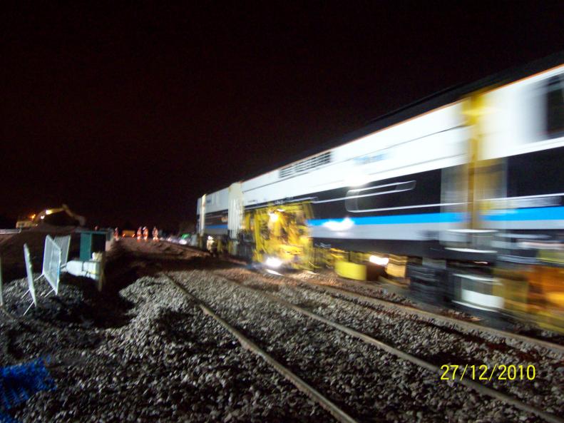 Tamper running across the bridge getting ready to pass through and tamp the track.