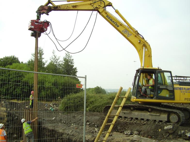 Excavator pitching and driving the sheet piles.