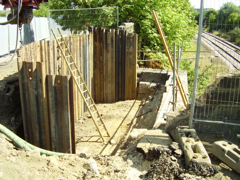 Sheet piles with the corner cut off to suit the services.