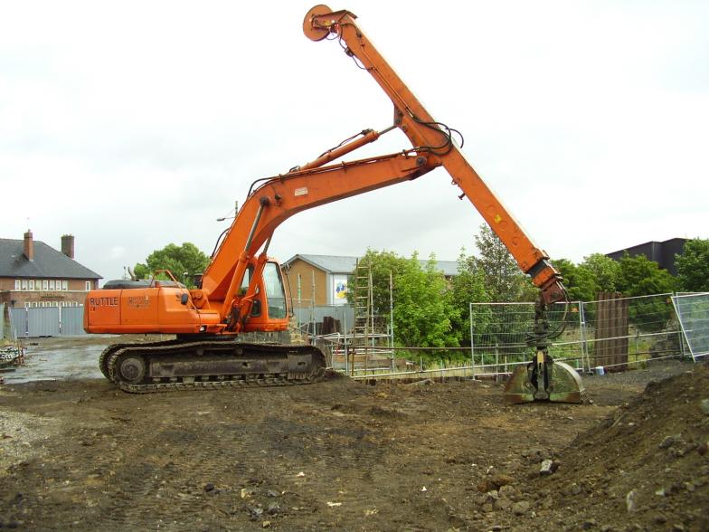 Excavator with grab on site to dig out down the back of the abutment.