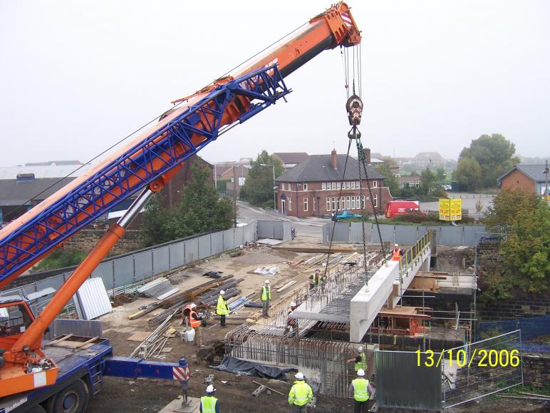 Concrete parapet unit being installed during normal working.