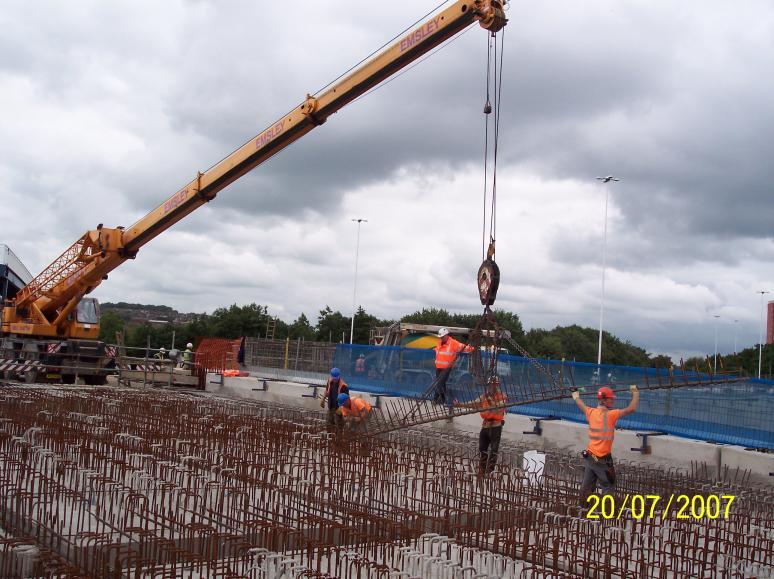 Mobile crane lifting in steel reinforcement onto the bridge.