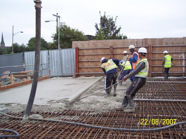 Concrete being placed and levelled using a roller screed.