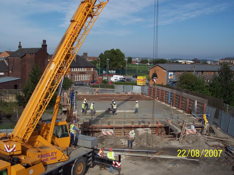 Crane being used to lift screed rails and screed of the deck at the end of the pour.