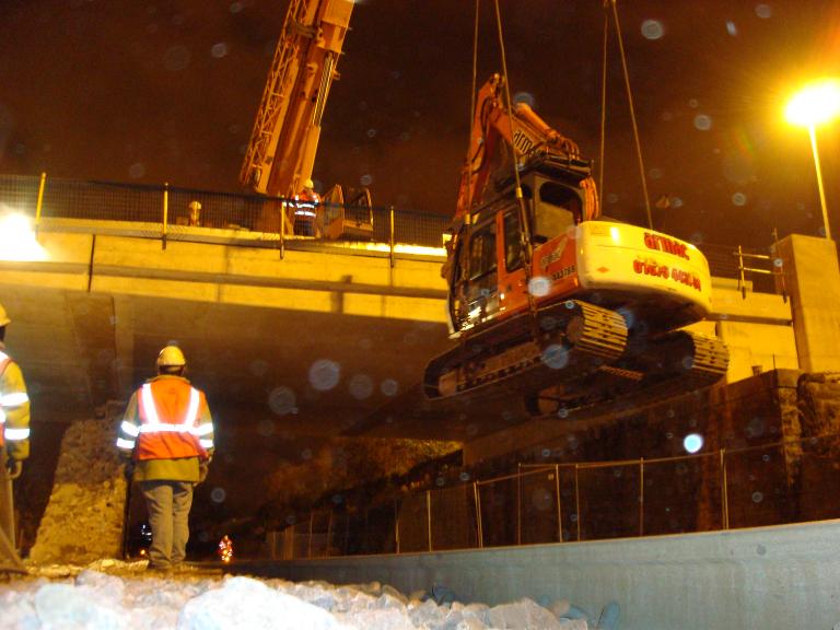 Crane lifting the excavators over the track during possession.