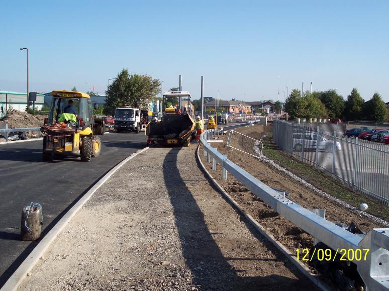 Footpaths being black topped with a mini paver.