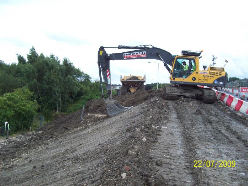 Excavator  creating the embankment over the infilled deck.