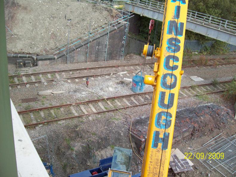 Crane and skip being used to break down the final section of the foundations