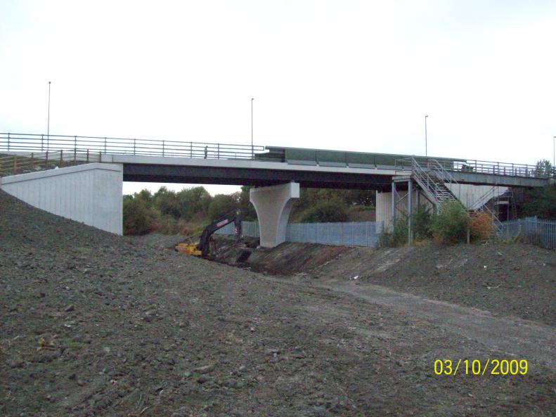 Pallasade fence being installed between the track and the canal.