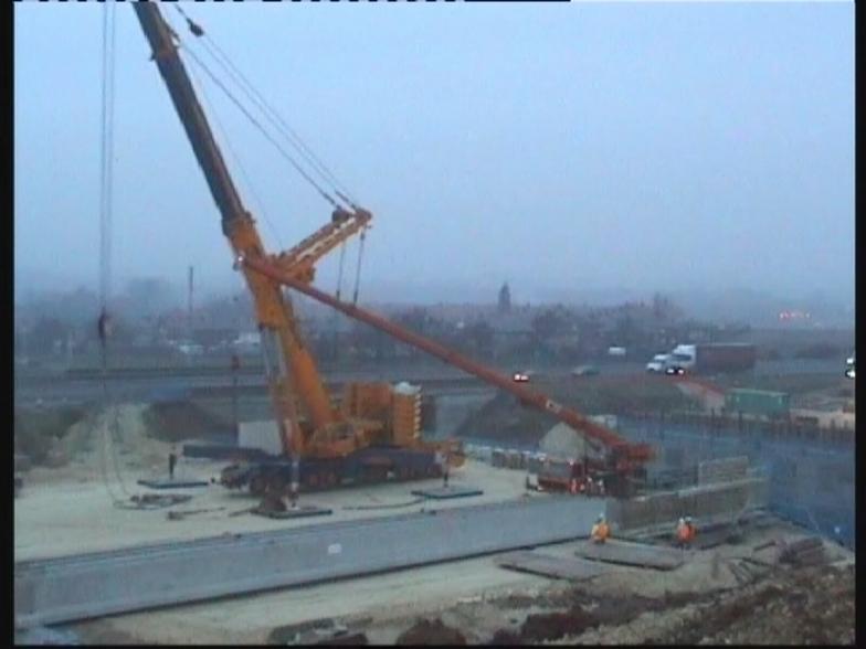 Crane lifting beams from the transport lorry
