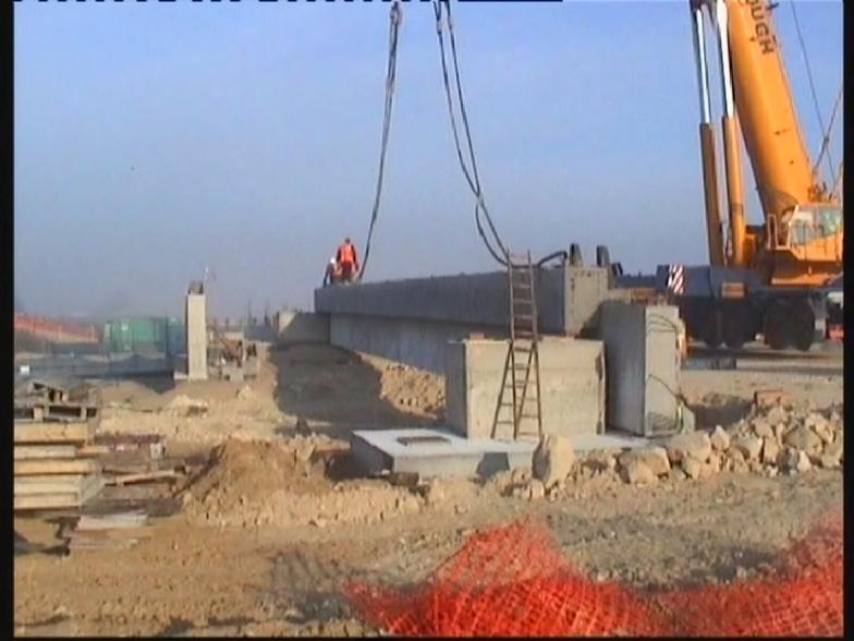 Crane landing the edge beam on to temporary support blocks